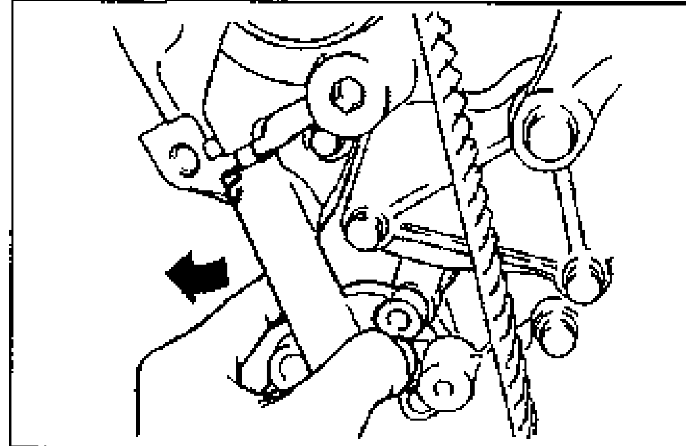 Auto tensioner being pushed in the direction of the arrow to install the lower bolt. An arrow points left toward the tensioner.