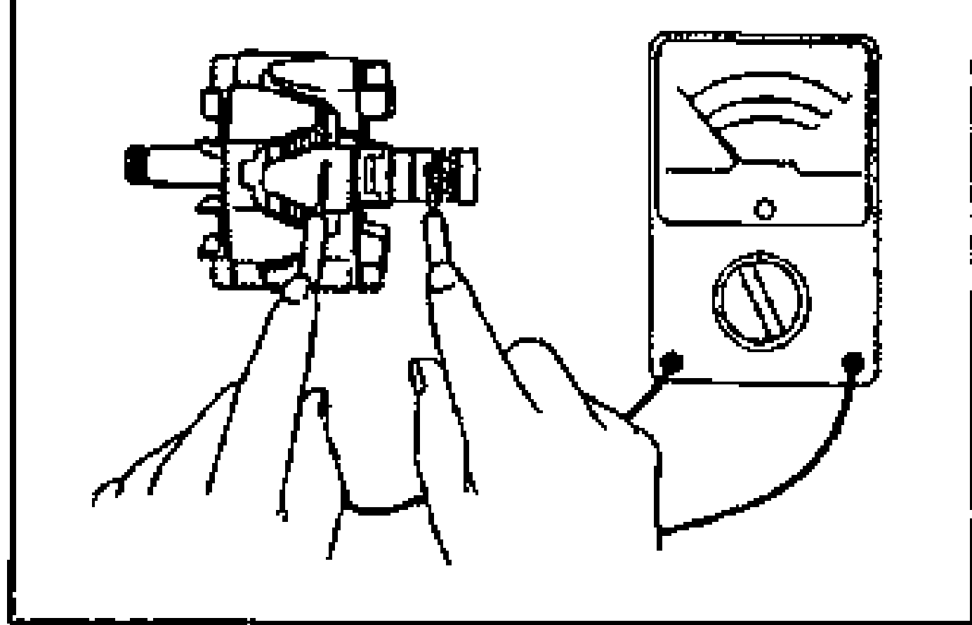 Hand holding the rotor with an ohmmeter probing between a slip ring and the core to check for continuity.