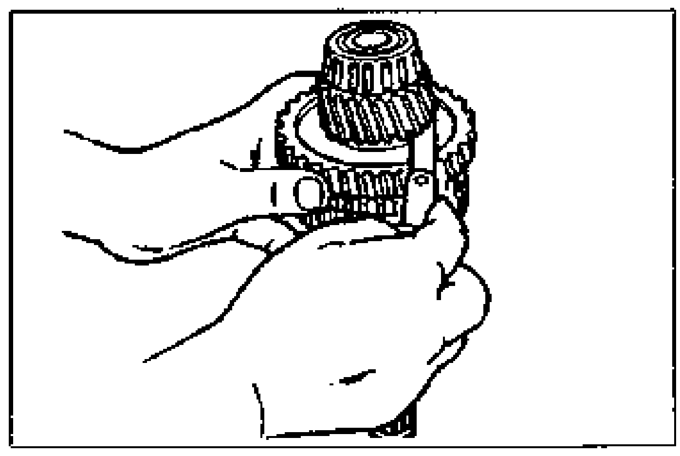 Hands holding the secondary shaft assembly while measuring the clearance between the 1st gear and the differential drive gear with a feeler gauge.