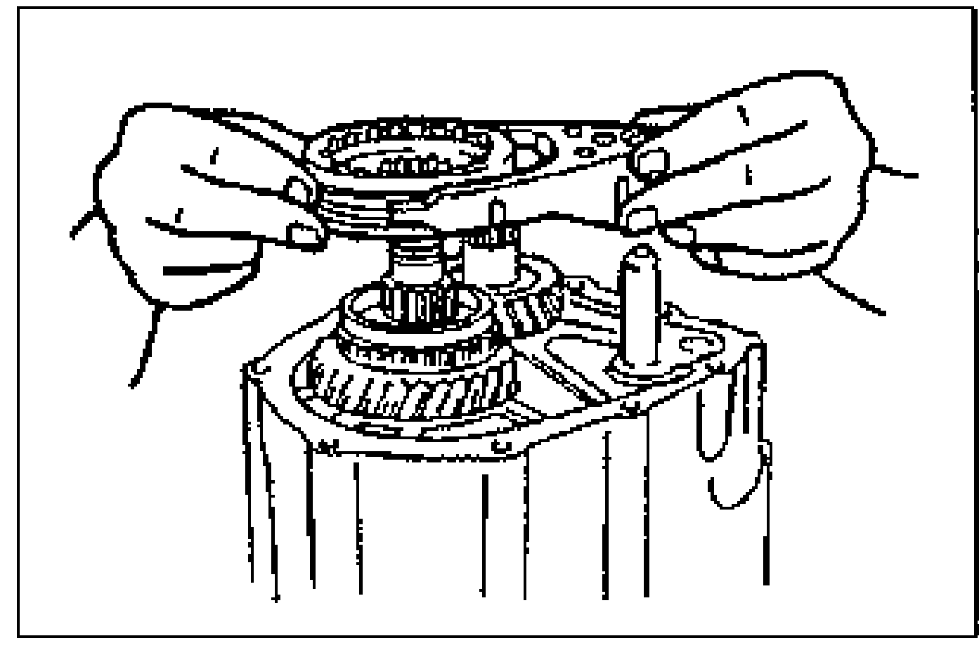 Photo of two hands installing the 5th/reverse clutch hub assembly together with the 5th/reverse shift fork onto the shaft.