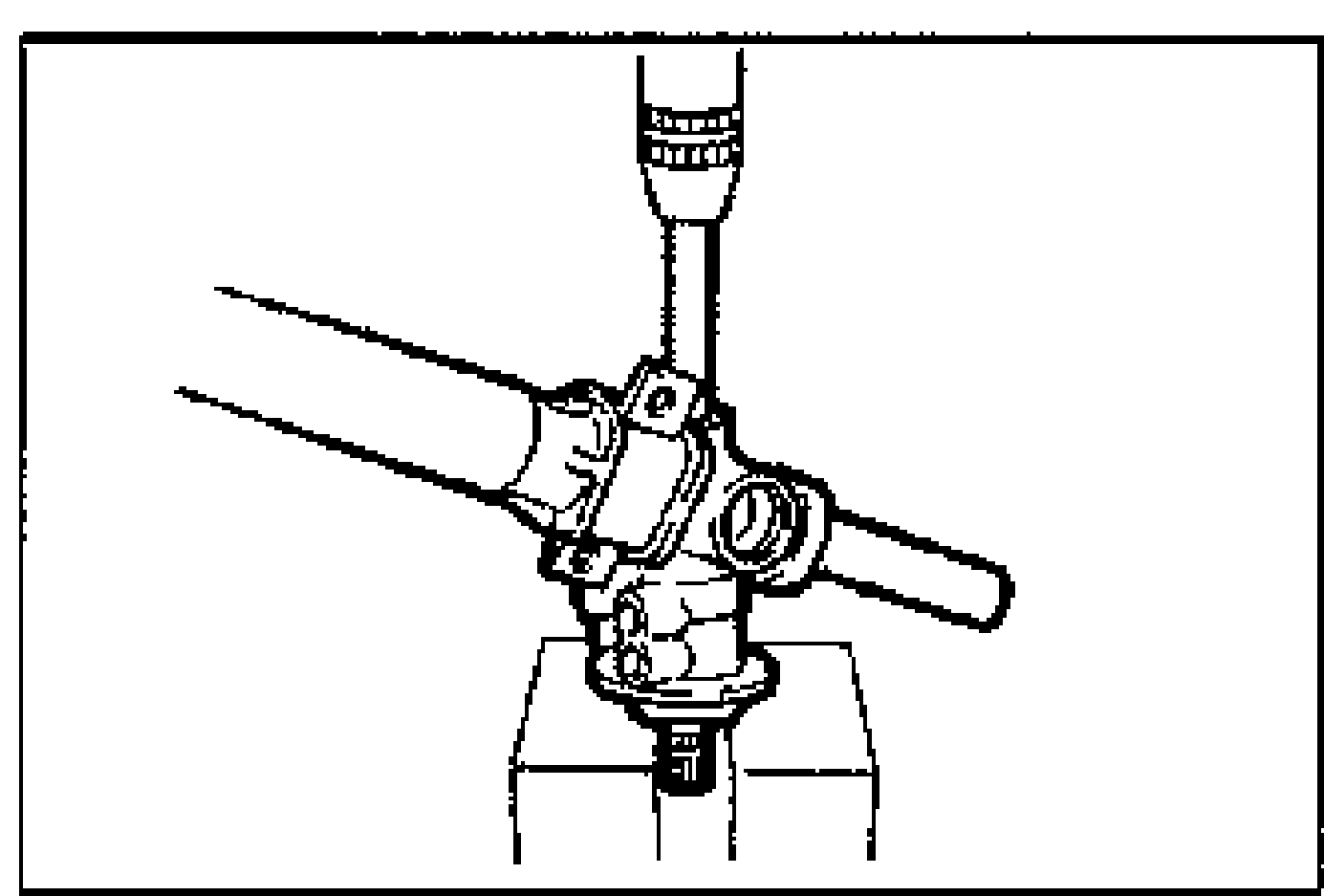 Gear housing assembly set on a press; pinion shaft assembly being removed.