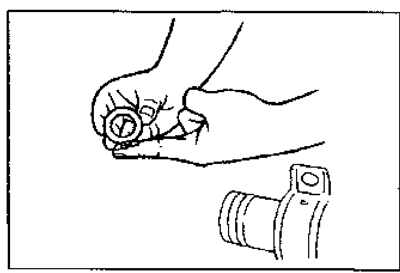 Line drawing of a hand applying grease to the flat surface of the spacer, with the steering housing tube shown lower right.